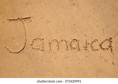 sign jamaica written on a beach sand