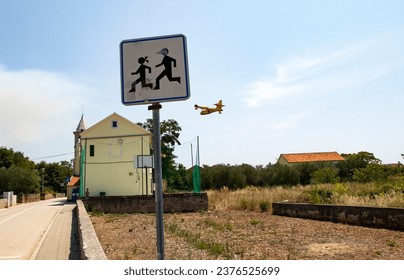 Sign kid on the road with road, church and plane in background - Powered by Shutterstock