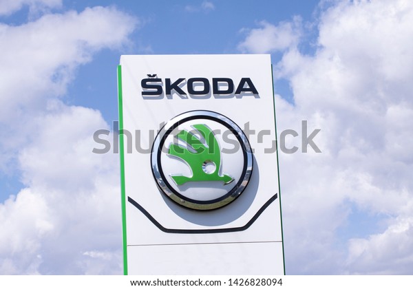 Sign with the logo of\
Škoda. Czech automobile manufacturer. In 2000 Škoda became a wholly\
owned subsidiary of the Volkswagen Group. Copenhagen, Denmark -\
June 17, 2019