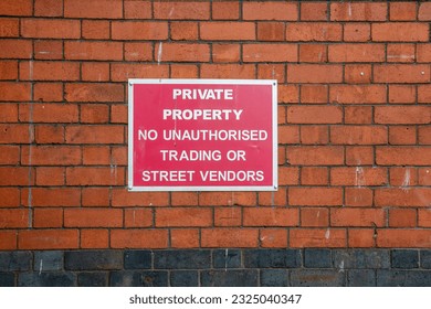 Sign on brick wall, private property, no unauthorised trading or street vendors - Shutterstock ID 2325040347