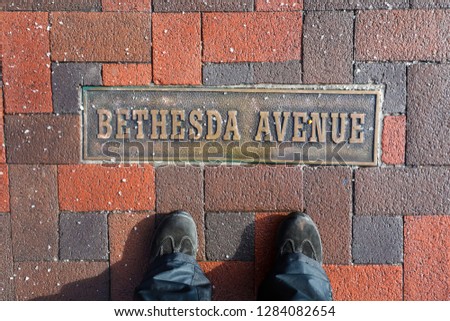 A sign on the ground labels Bethesda Avenue, a popular street for shopping and restaurants in the Chevy Chase neighborhood in Montgomery County. 