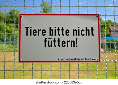 Sign on Metal Outdoor Animal Cage 'Please Don't Feed The Animals' Translated from German  - Shutterstock ID 2253836605
