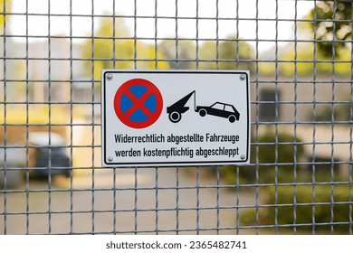Sign on a property entrance saying that parking is prohibited and cars will be towed away. German traffic sign forbidding staying on the driveway.