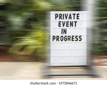 Sign In Ornamental Garden - Private Event In Progress - Surrounded By Motion Blur Of Sidewalk, Display Stand, And Greenery, For Concepts Of Restriction And Time, Perception, Alternate Reality