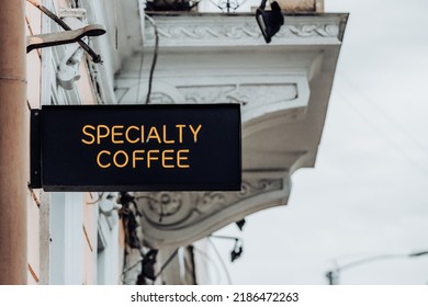 Sign Outside A Coffeeshop That Says 'Specialty Coffee'. Coffeehouse Advertising Banner At The Entrance Up On A Wall