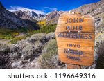 Sign posted at the entrance to the John Muir Wilderness, in the Inyo National Forest; Eastern Sierra mountains, California; McGee valley visible in the background; beautiful sunny fall day