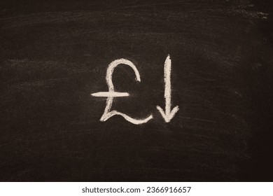 The sign of the pound sterling, the franc is written on a black board with a down arrow as a concept of a currency falling. - Powered by Shutterstock