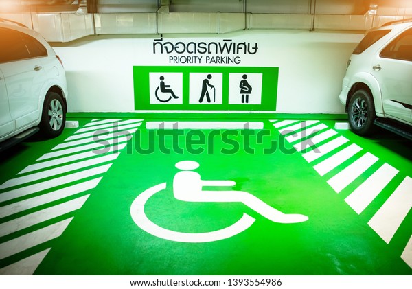sign of priority parking for disable\
person, old man and pregnant. green sign in the car parking lot of\
shopping mall of the city, handicap car parking\
lot