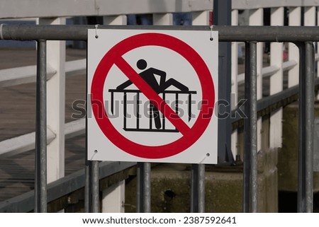 A sign prohibiting jumping over barriers at a concert or bridge, safety during mass events and accident prevention