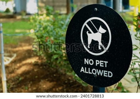 Sign in a public park warning that dogs are not permitted.