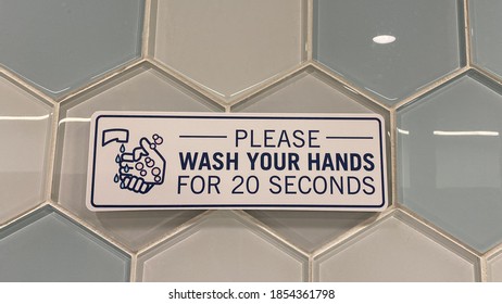 A Sign In A Public Restroom That Tells People To Please Wash Your Hands For 20 Seconds Due To The Coronavirus Pandemic.