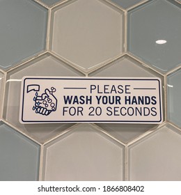 A Sign In A Public Restroom That Tells People To Please Wash Your Hands For 20 Seconds Due To The Coronavirus Pandemic.