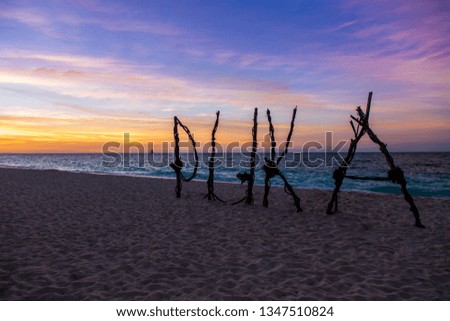 The sign of puka beach during the sunset