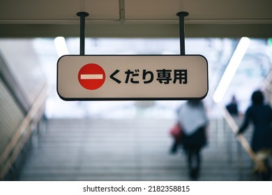 Sign reading "kudari senmon" (down only) on steps in a Japanese subway system with the international do not enter emblem. 