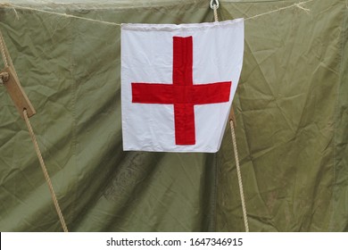The sign of the red cross on a canvas army tent. Mobile military hospital.