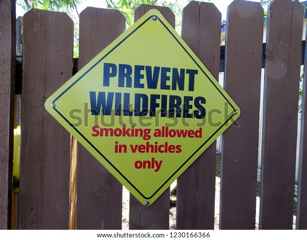 A sign\
requesting prevention of wildfires showing smoking allowed in\
vehicles only                          \
