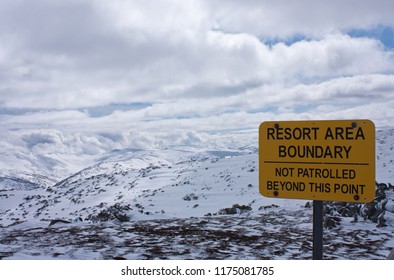 A Sign Resoet Area Boundary In Perisher Ski Resort In Australia In Winter, In The Distance Snow Covered Mountains