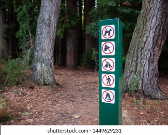 Sign Of Rules Of Entering The Forest On Side Of Footpath. The Sign Indicates That Bringing Dogs, Hunting, Camping, Littering And Having Campfire Are Not Allowed. Redwood Forest, Warburton, Australia.