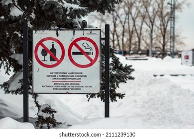 A sign in Russian and English with the text on the territory of the embankment smoking and consumption (drinking) of alcoholic products