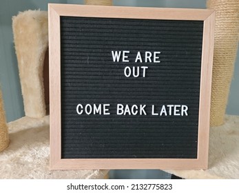 A Sign Saying We Are Out Come Back Later. The Felt Sign Has Removable Letters Than Can Be Moved Around To Make Whatever Words Or Saying One Wants.