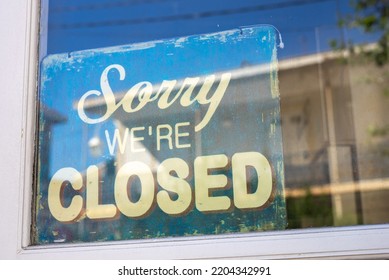 Sign in the shop window behind a pane of glass saying 'Sorry we're closed'. the shop is closed. end of business. closure of business. modern font. - Powered by Shutterstock