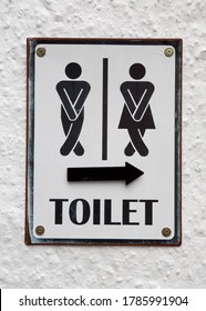 Sign showing a man and a woman crossing their legs needing to use a public toilet with an arrow pointing the way.
 - Shutterstock ID 1785991904