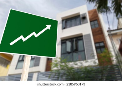 A Sign Showing An Upward Arrow In Front Of An Apartment Building. Concept Of Increasing Home Prices And Value Or A Real Estate Boom.