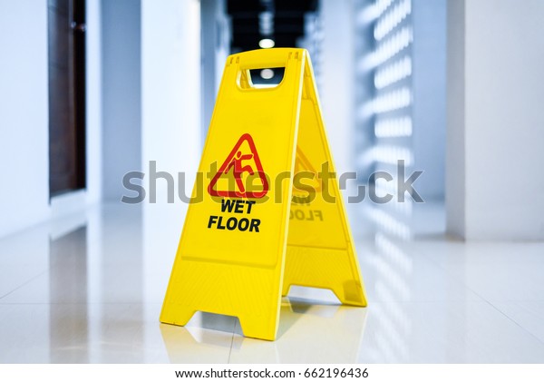 Sign showing\
warning of  wet floor on wet  floor\
