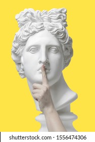 Sign of silence. Gypsum statue of Apollo's head, holding finger on his lips. Statue. Keep silence. The secret concept. Pandemic. Social distancing. quantum vaccine. Coronavirus Covid-19 outbreakin. 