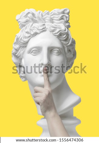 Sign of silence. Gypsum statue of Apollo's head, holding finger on his lips. Statue. Keep silence. The secret concept. Pandemic. Social distancing. quantum vaccine. Coronavirus Covid-19 outbreakin. 