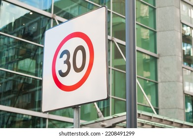 Sign speed limit 30 miles, kilometers per hour in the city skyscraper background. Poland, Warsaw, restriction road sign. Editorial. Traffic sign, traffic safety. Modern