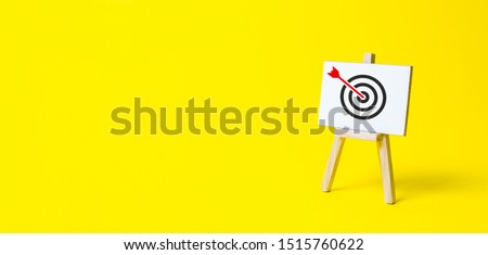 Sign stand with an arrow in the target on a yellow background. Hit exactly on center. Tactics of advertising targeting. advertise campaigns. Goal Achievement and Purposefulness