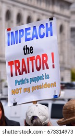 A sign stating "Impeach the traitor! Putin's puppet is NOT my president" is being held high at the Tax Day March, Civic Center San Francisco, April 15, 2017.