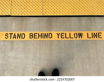 Sign Stating Stand Behind Yellow Line With A Sight Impaired Barrier At A Train Station