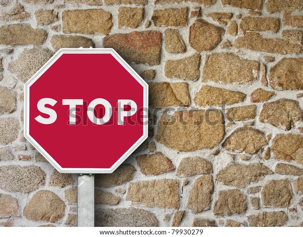 sign stop on stone\
wall