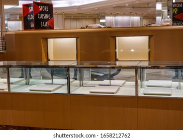 Sign For A Store Closing Sale On Top Of An Empty Jewelry Display Case With Empty Illuminated Shelves