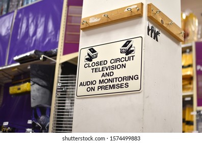 A sign in a store warns shoppers that they are being monitored on a closed-circuit television cctv camera.