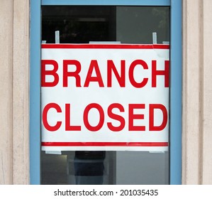 A sign in a store window reading Branch Closed