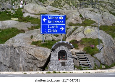 Sign At Swiss Mountain Pass Named St. Gotthard With Memorial For The Death Of Railway Basic Tunnel Construction Workers On A Sunny Summer Day. Photo Taken June 25th, 2022, Gotthard Pass, Switzerland.