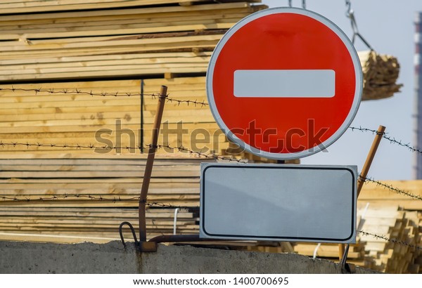 sign, symbol, warning about the\
prohibition of entry to the territory of the industrial zone with\
building materials, lumber, placed on the fence with barbed\
wire