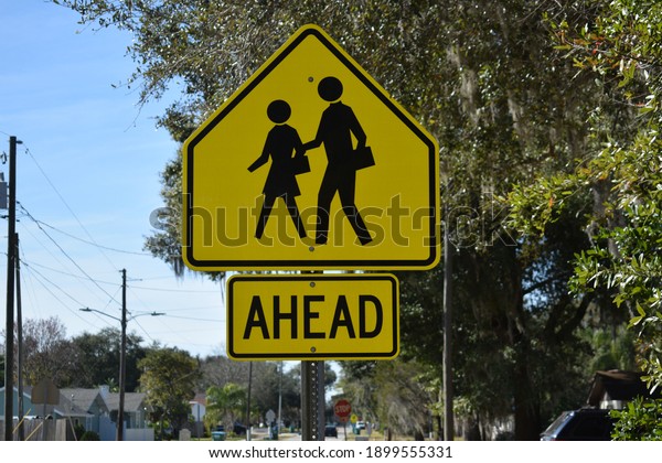 A sign symbolizes\
a school crossing zone.