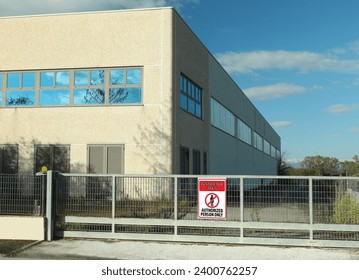 Sign with text Restricted Area Authorized Person Only on fence near factory building outdoors - Powered by Shutterstock