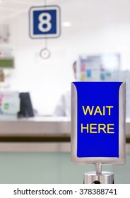 sign with text WAIT HERE before counter