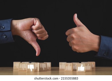 Sign Of Thumbs Up And Thumbs Down To Show The Like And Unlike Feeling. Hands And Wood Blocks Isolated On Black Background. Evaluation And Satisfaction Concept