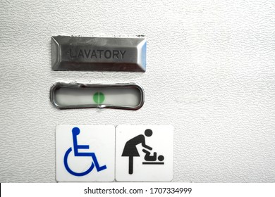 A Sign In The Toilet Of An Airplane, Meaning That The Toilet Is Equipped For Disabled People. And It Has A Changing Table.