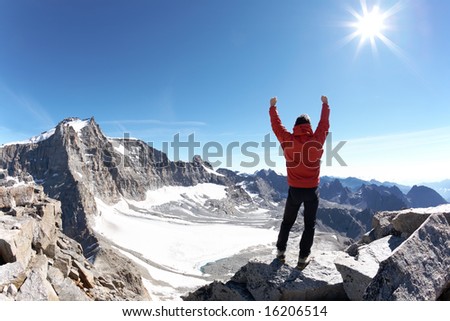 Sign of victory: climber on the top of the mountain. Gran Paradiso National Park, Italy