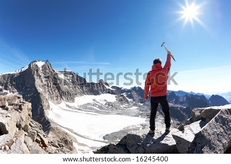 Sign of victory: climber on the top of the mountain. Gran Paradiso National Park, Italy