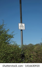 Sign warning of anti-climb paint on tall pole, West Midlands, UK