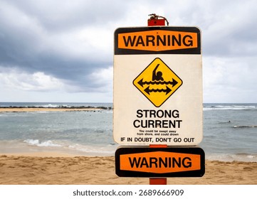 A sign warning of strong currents and sharp coral at a beach