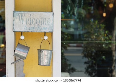 The Sign To Welcome The Storefront Has An Aluminum Tank Hanging On It.